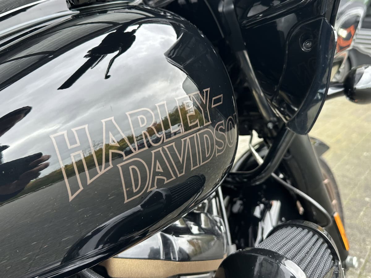 Harley-Davidson Tank mit Logo, schwarzes glänzendes Motorradteil, Detailaufnahme.