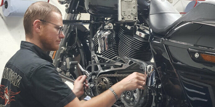 Harley-Davidson Motorrad Werkstatt, Mechaniker bei Reparatur, professionelles Bike-Tuning.