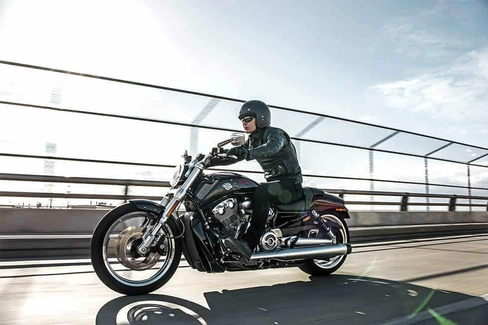 Leichter Motorradfahrer auf Harley Davidson auf einer Brücke fahrend.
