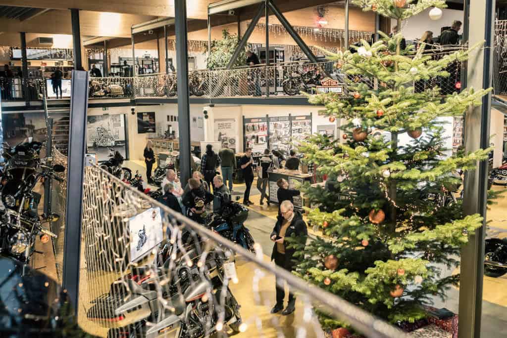 H-D® YOUR BIKE HOUSE Inneneinrichtung mit Motorrädern und Weihnachtsbaum in der Harley-Davidson Filiale.
