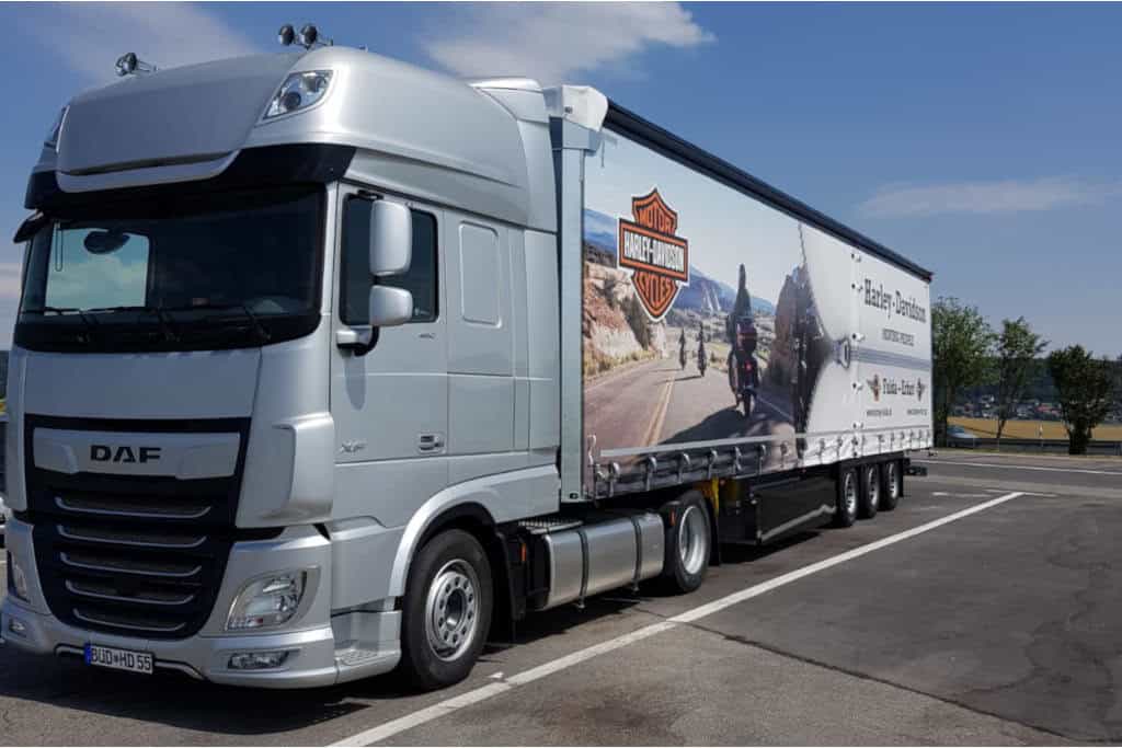 LKW mit Harley-Davidson Werbung, Beladung, Motorrad-Transport, Harley-Davidson Logo, Roadtrip, Auto, Parkplatz.