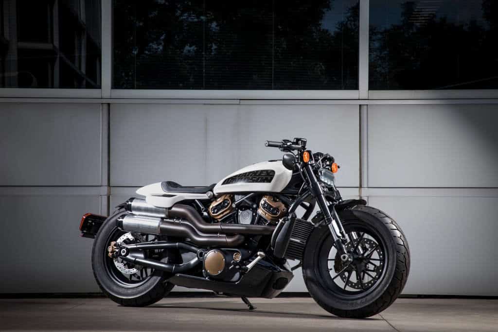 Harley-Davidson Softail Sport Glide in Schwarz und Weiß, stilvoll vor moderner Fassade.