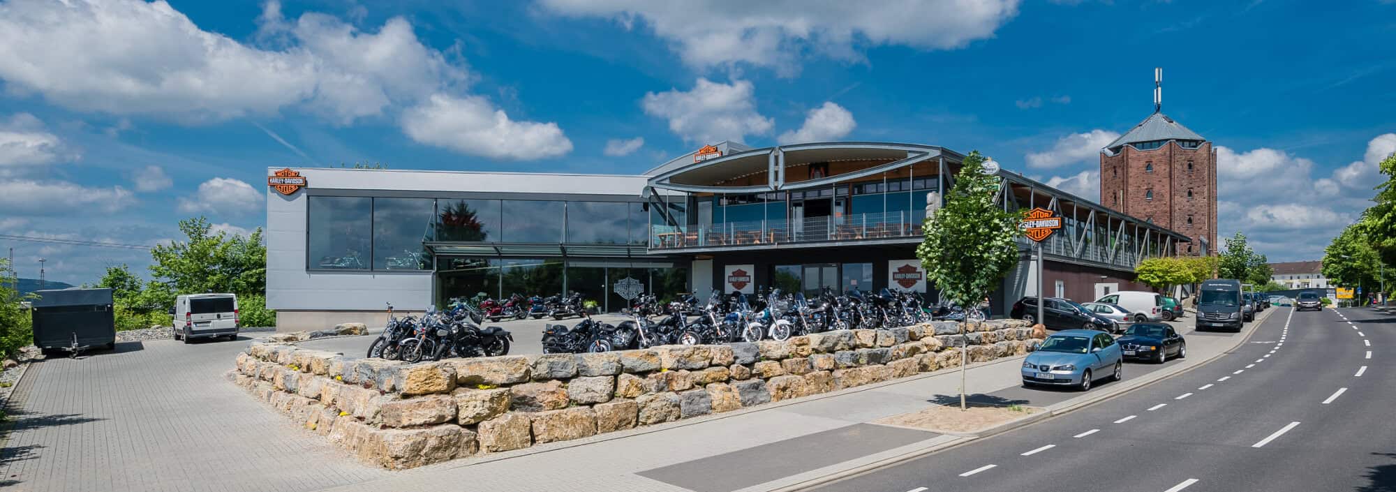 Harley-Davidson Motorradgeschäft, modernes Gebäude mit Motorrädern vor dem Laden.